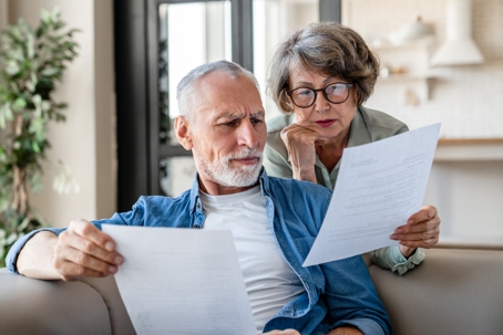 elderly couple poring over documents